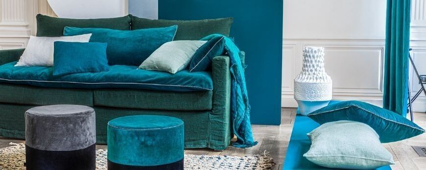 Édredon et coussins en velours bleu canard sur un canapé assorti – Plaid Addict