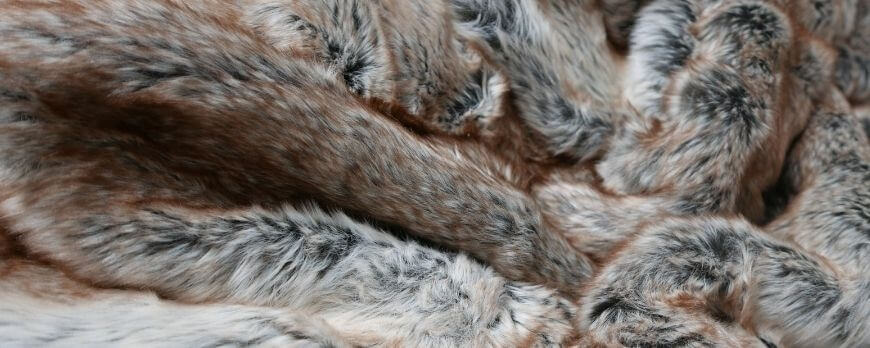 Gros plan sur un plaid en fausse fourrure aux nuances fauve et grises – Plaid Addict
