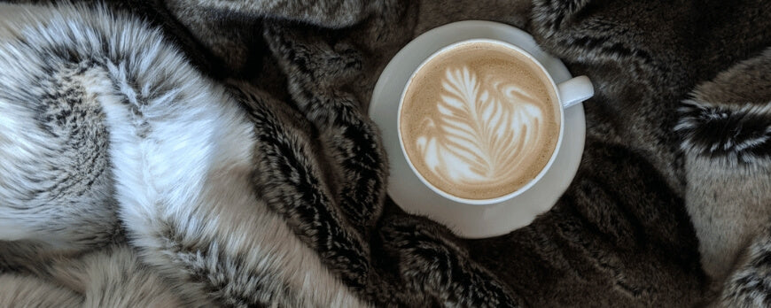 Cappuccino posé sur un plaid en fausse fourrure brune, ambiance chalet – Plaid Addict