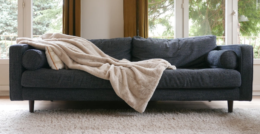 Plaid en fausse fourrure beige sable jeté sur un canapé anthracite – Plaid Addict