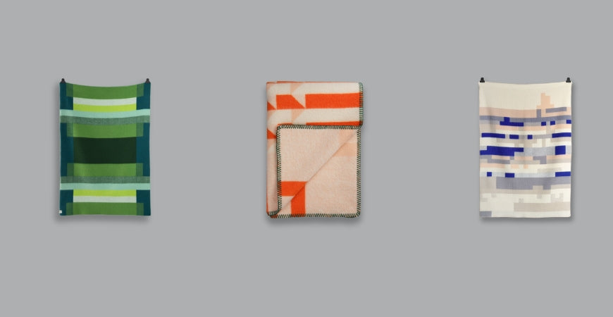 Trois plaids graphiques aux motifs colorés vert, orange et bleu suspendus – Plaid Addict