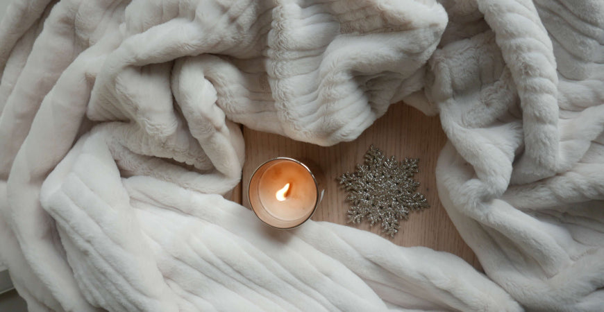 Plaid en fausse fourrure ivoire côtelée avec bougie allumée, ambiance hygge – Plaid Addict
