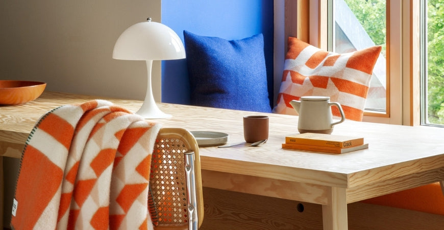 Plaid graphique orange et écru sur une chaise cannée, décoration lumineuse – Plaid Addict