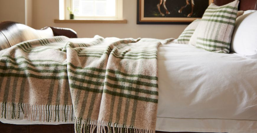 Plaid XXL à carreaux vert olive et beige déployé sur un lit ancien – Plaid Addict