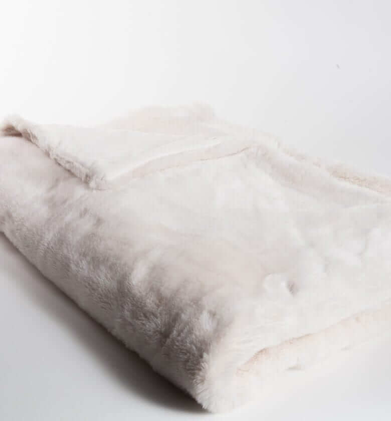 Plaid Fausse Fourrure LUXE Blanc cassé 130 x 180 cm, Plaid Addict, drapé sur un canapé