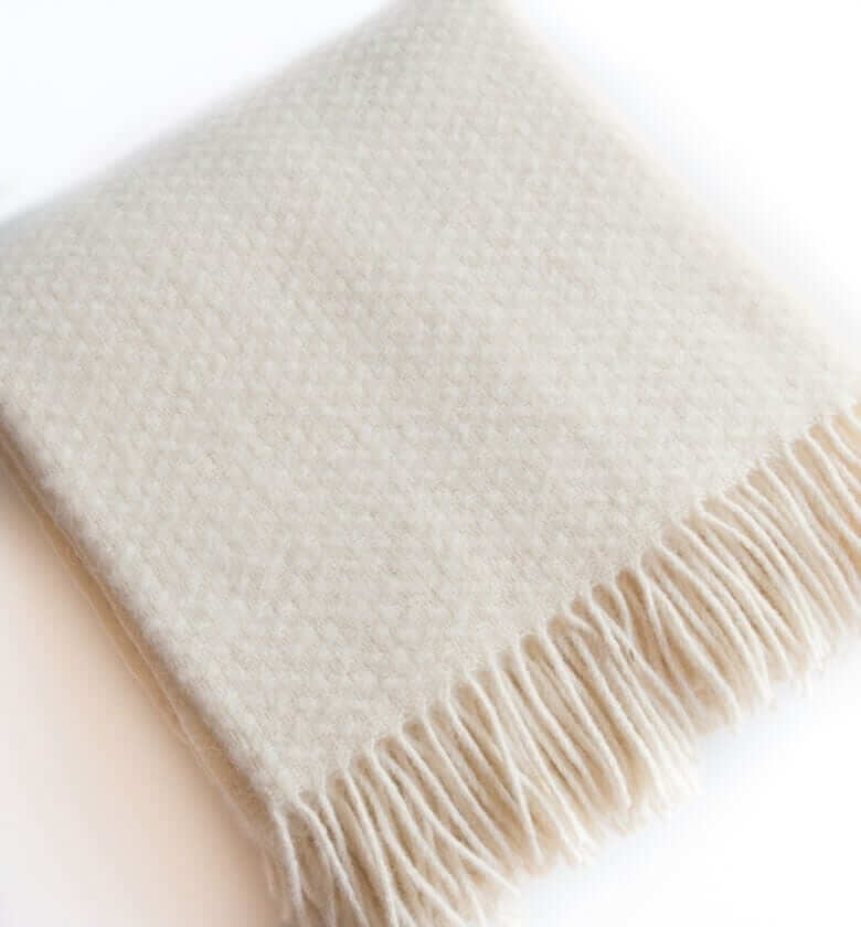 Plaid Laine Uni Blanc cassé Wafer 150 x 183 cm, The Mill, drapé sur un canapé