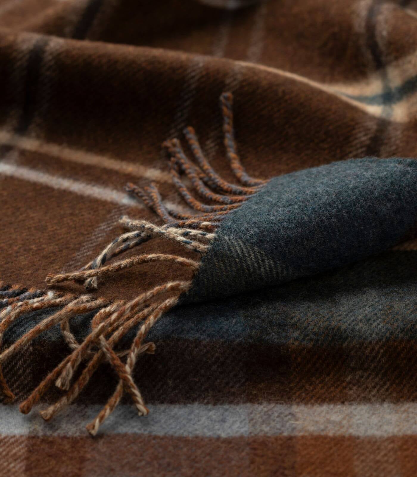 Plaid Laine Écossais Réversible Luxe Brun et Bleu 140 x 190 cm, Johnstons of Elgin, drapé sur un canapé