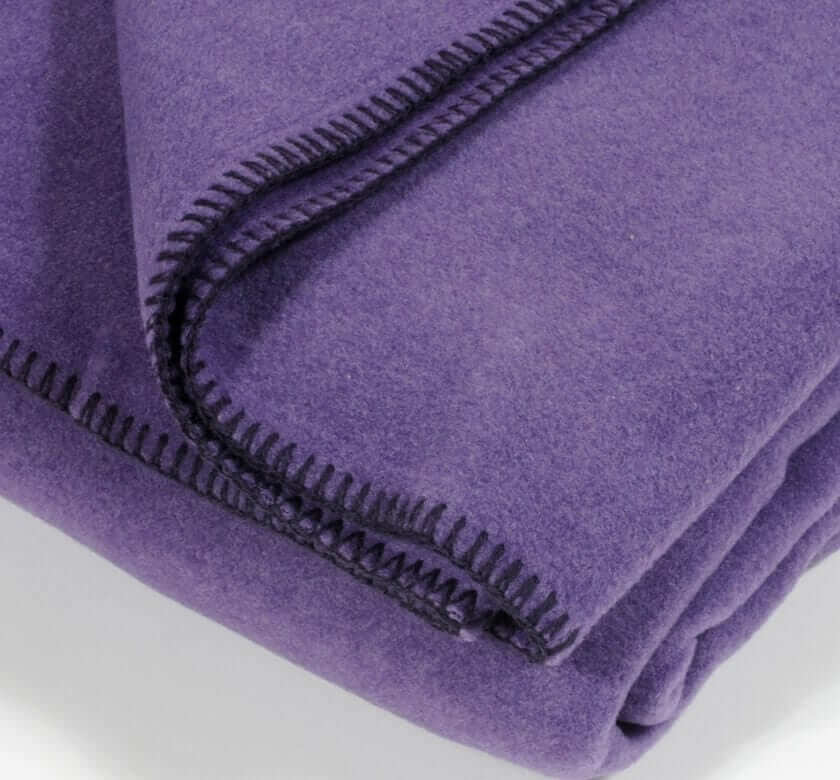 Plaid Polaire Luxe Aubergine - format 110 X 160 cm drapé sur canapé