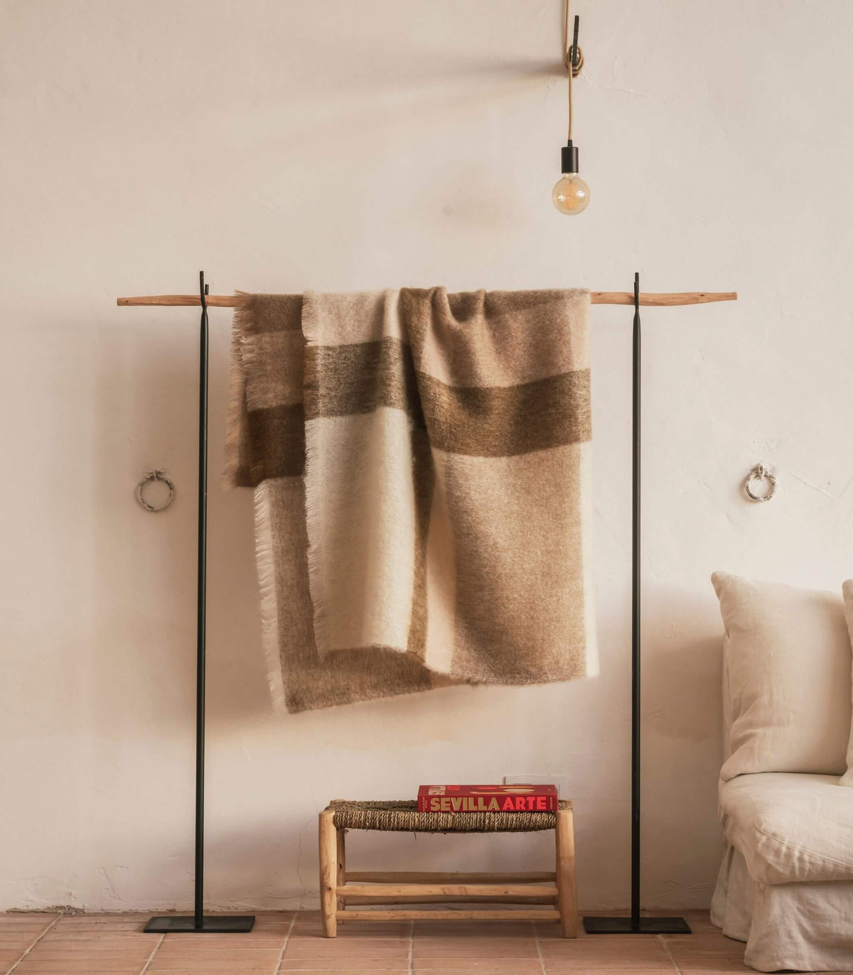 Plaid mohair à carreaux naturels suspendu dans un intérieur chaleureux