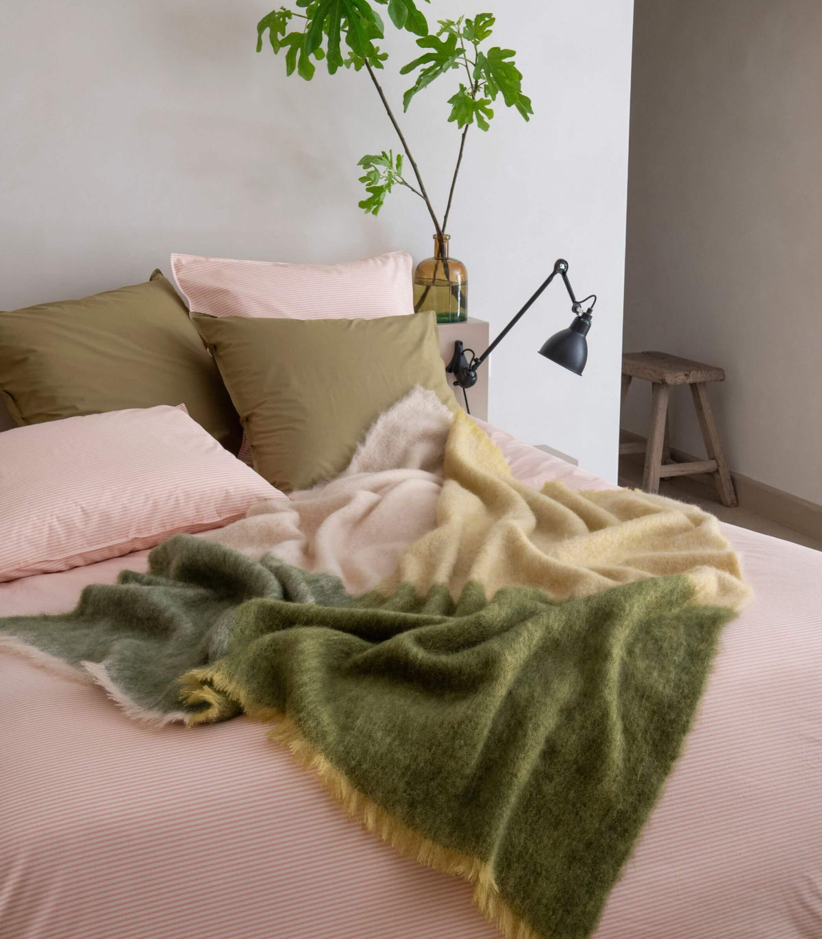 Plaid mohair vert et beige posé sur un lit