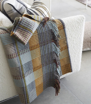 Plaid Tasara présenté sur un canapé pour mise en situation signé Designers Guild