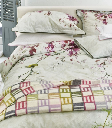 Plaid Laine Mérinos Rose et Naturel mis en situation en bout de lit dans une chambre