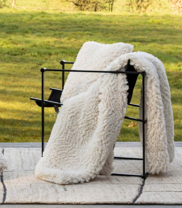 Plaid fausse fourrure effet mouton blanc cassé 140x180 cm déplié sur fauteuil