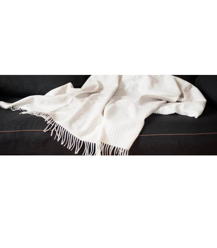 Plaid Cachemire Everest Beige, Lanerossi, drapé sur un canapé