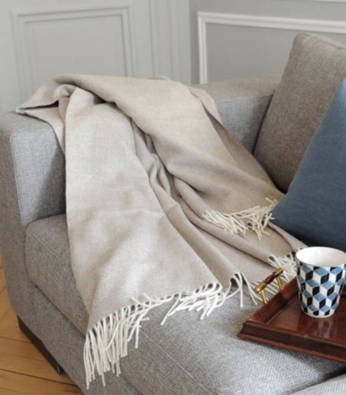 Plaid Laine Alpaga Luxe Inca Chic Beige 130 x 180cm, Casa Paola, drapé sur un canapé