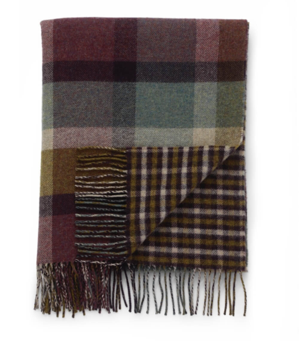 Plaid Laine Écossais Réversible Luxe Aubergine et Vert 140 x 190 cm, Johnstons of Elgin, drapé sur un canapé