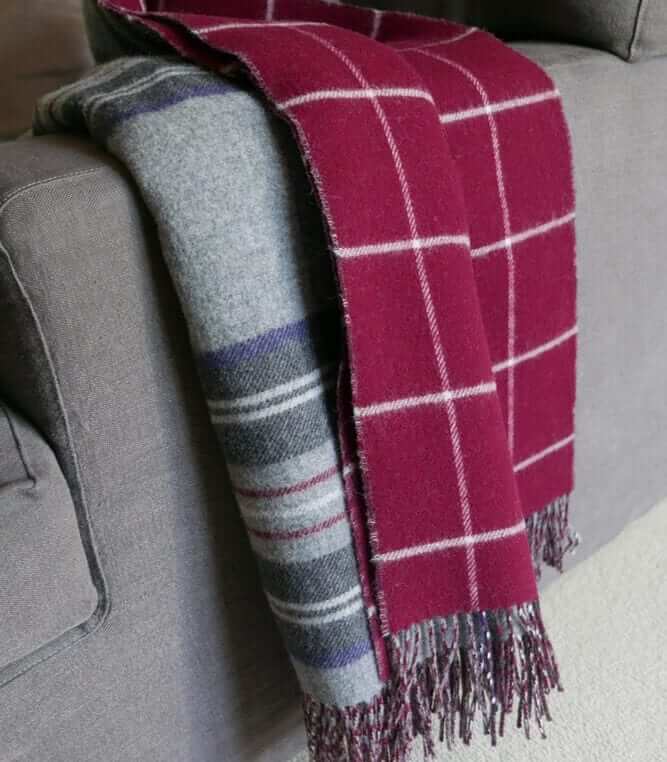 Plaid Laine Écossais Réversible Luxe Gris et Bordeaux 140 x 190 cm, Johnstons of Elgin, drapé sur un canapé