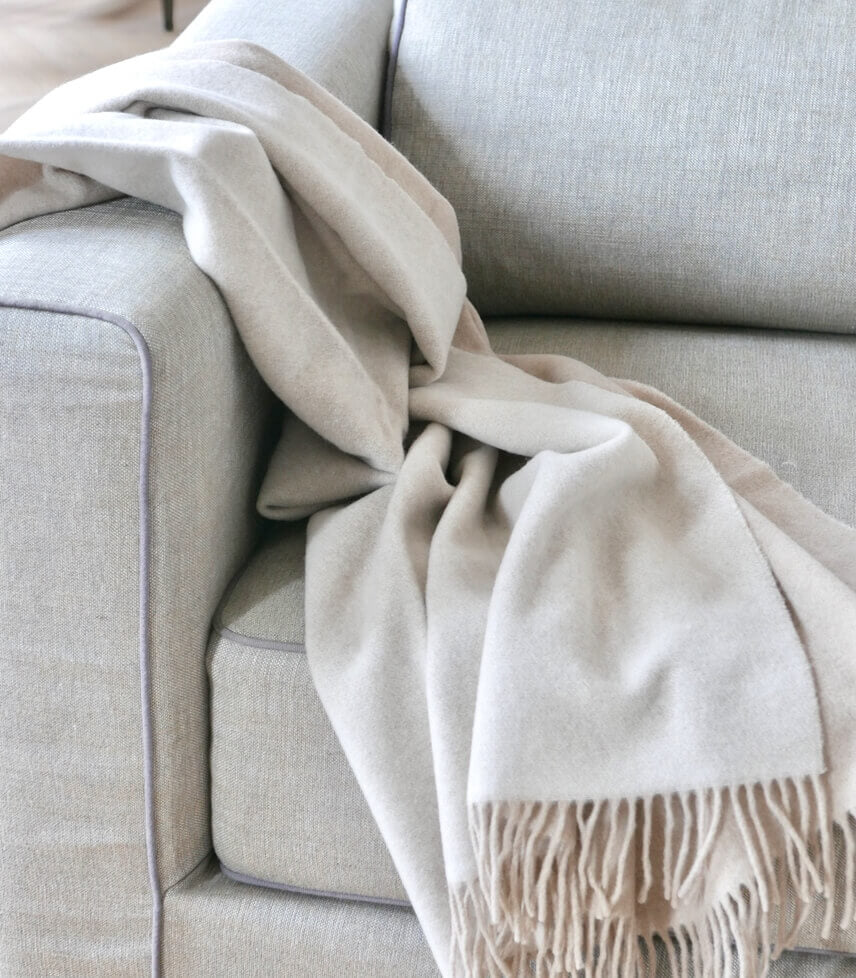 Plaid Pure Laine Douce Reversible Beige et Crème 130 x 170 cm - Collection VENICE, Plaid Addict, drapé sur un canapé