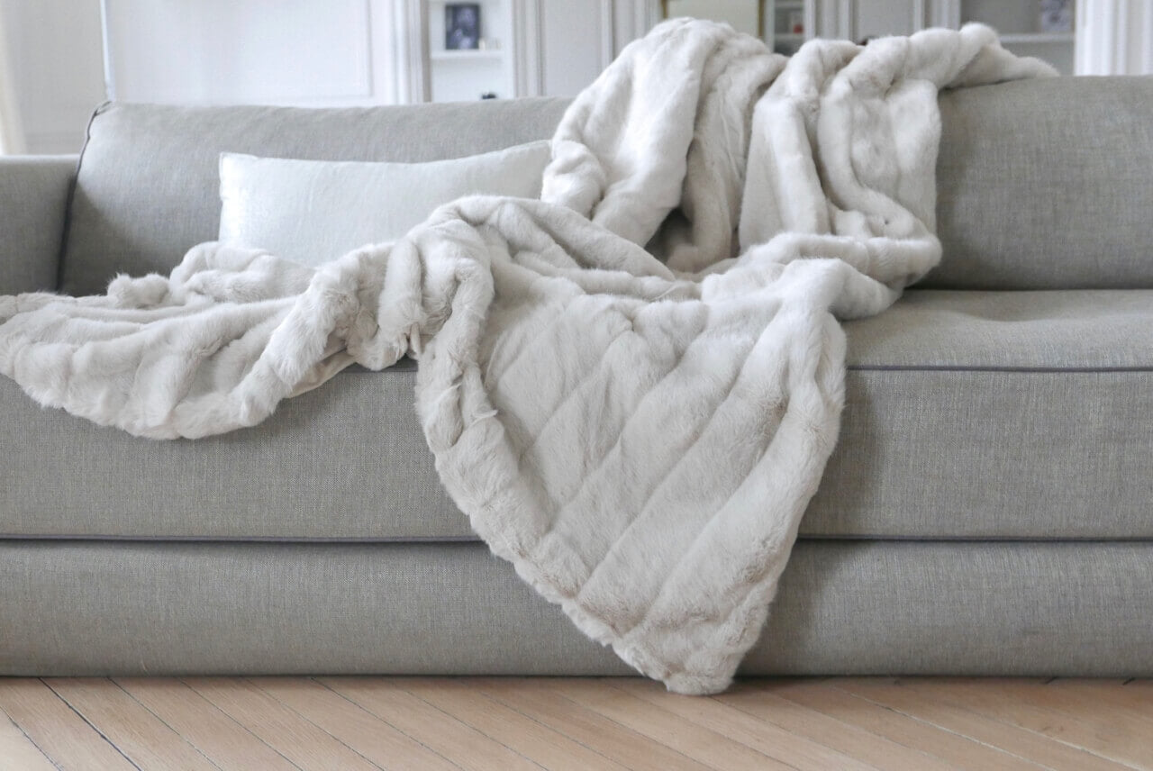 Plaid Couverture Fausse Fourrure Blanc Ivoire 170 x 240 cm, Plaid Addict, drapé sur un canapé