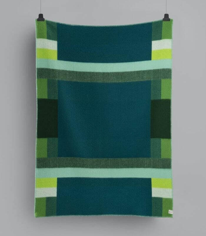 Plaid Pure Laine Mikkel Vert 135 x 200 cm, Roros Tweed, drapé sur un canapé