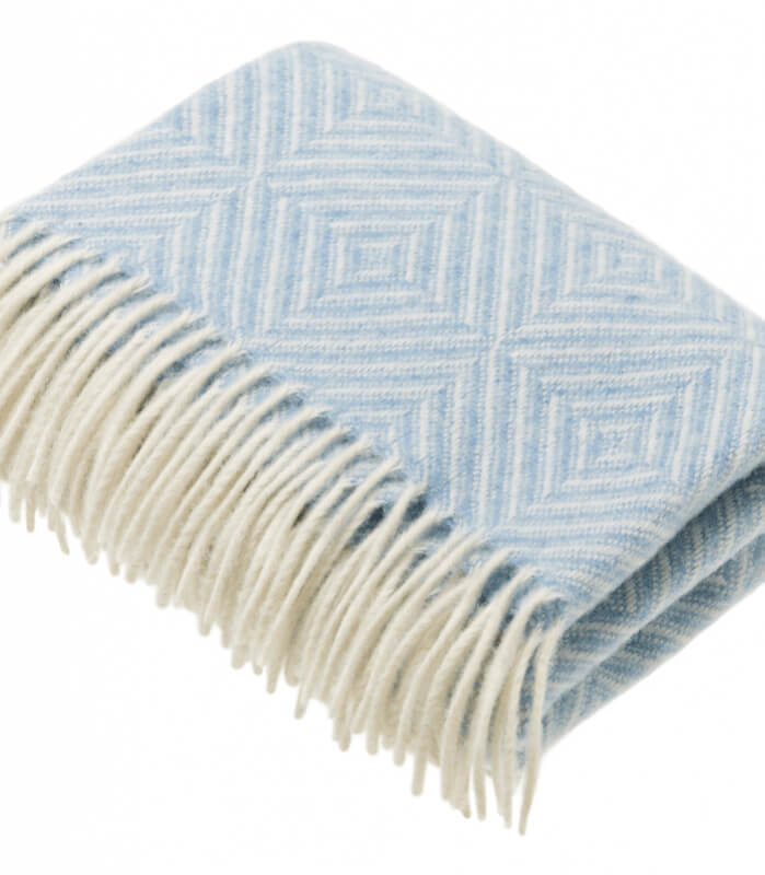 Couverture Bébé Mérinos Bleu 75 x 125 cm, Plaid Addict, drapée sur un lit bébé