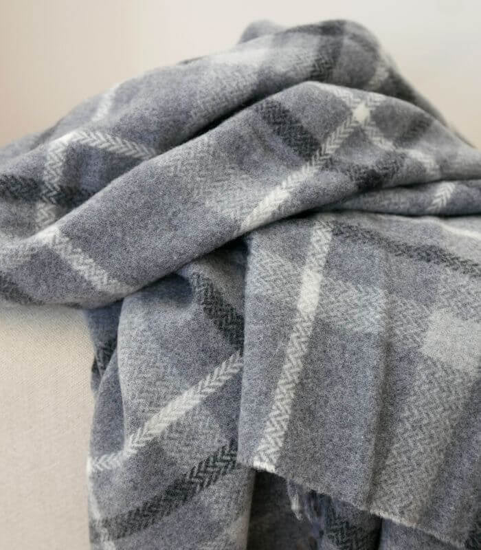 Plaid 100% Pure Laine Carreaux Gris - Collection CAPRI - Douceur et Qualité, Plaid Addict, drapé sur un canapé
