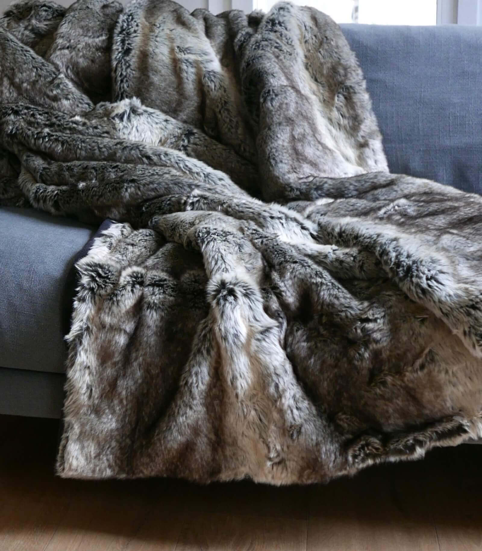 Plaid Couverture en Fausse Fourrure Grizzly 130 x 170 cm, Plaid Addict, drapé sur un canapé