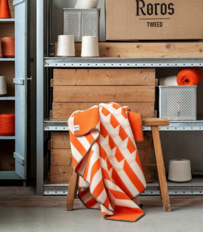 Plaid Pure Laine Design Kvam Orange 135 x 200 cm, Roros Tweed, drapé sur un canapé