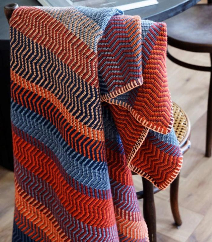 Plaid Pure Laine FRI Rouge et Bleu 150 x 200 cm, Roros Tweed, drapé sur un canapé
