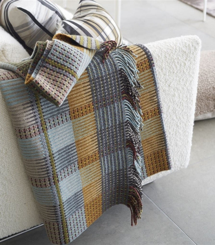 Plaid Tasara présenté sur un canapé pour mise en situation signé Designers Guild