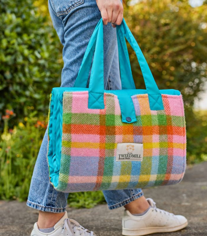 Plaid Pique Nique Laine Rainbow Check Coloré 137 x 170 cm, The Mill, drapé sur un canapé
