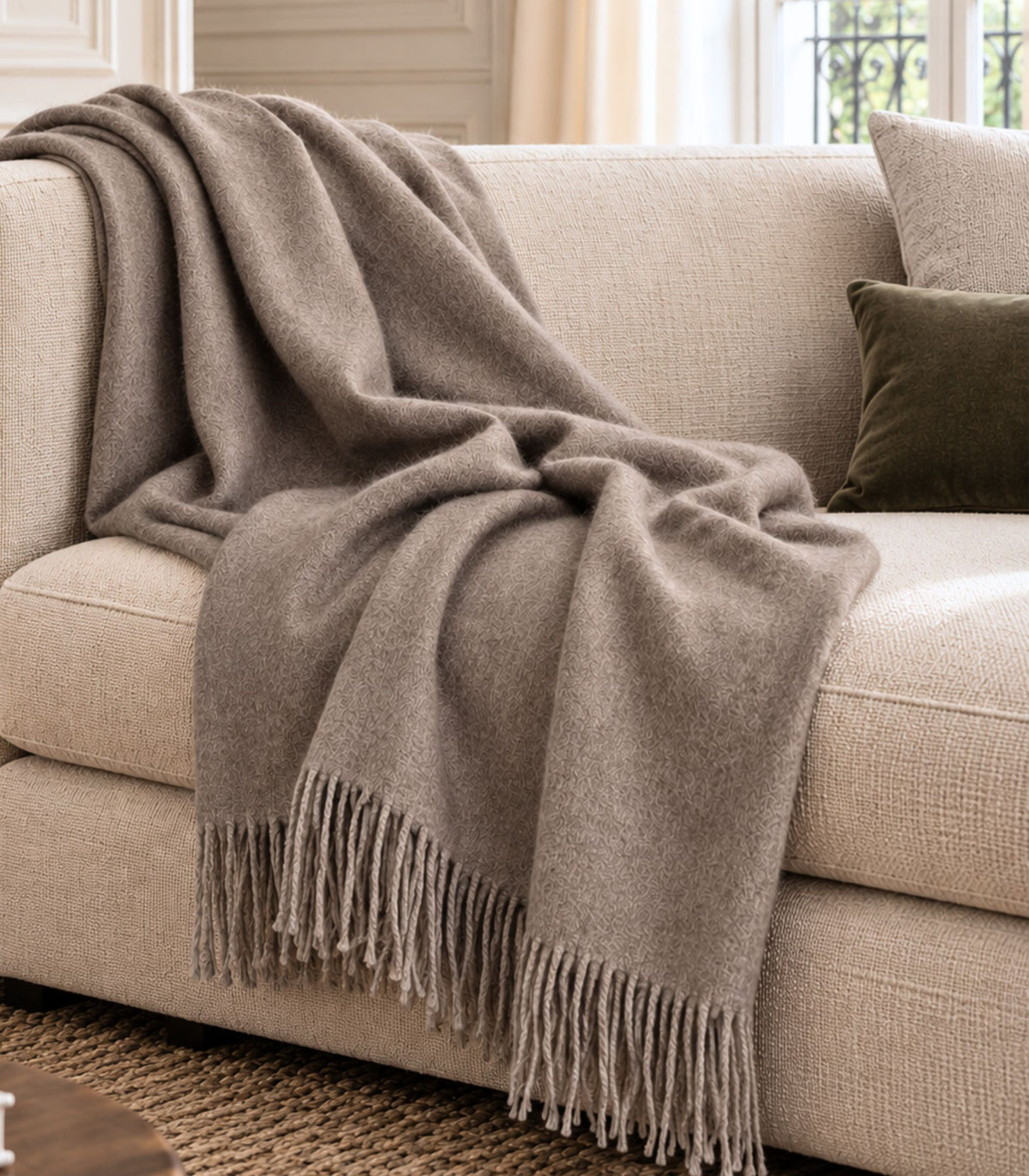 plaid en alpaga taupe déplié sur canapé