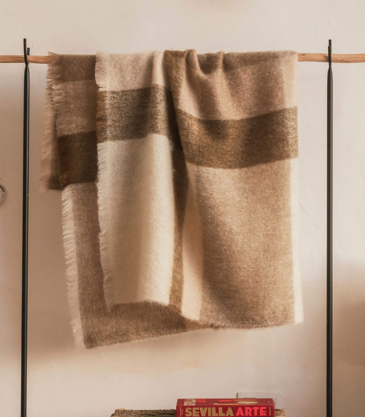 Plaid mohair à carreaux naturels suspendu dans un intérieur chaleureux