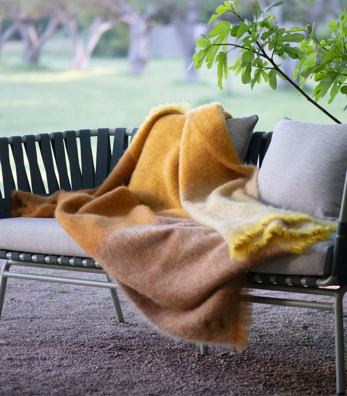 Plaid mohair ocre posé sur un canapé dans un intérieur lumineux