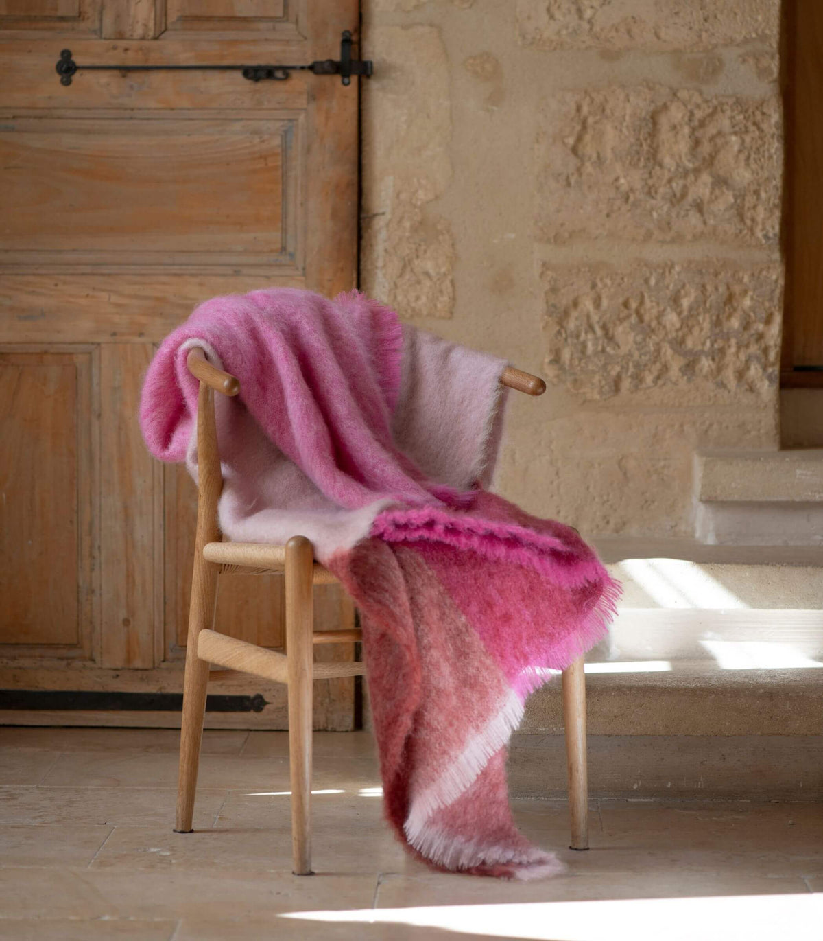 Plaid multicolore rose en mohair dans un intérieur aux matières naturelles