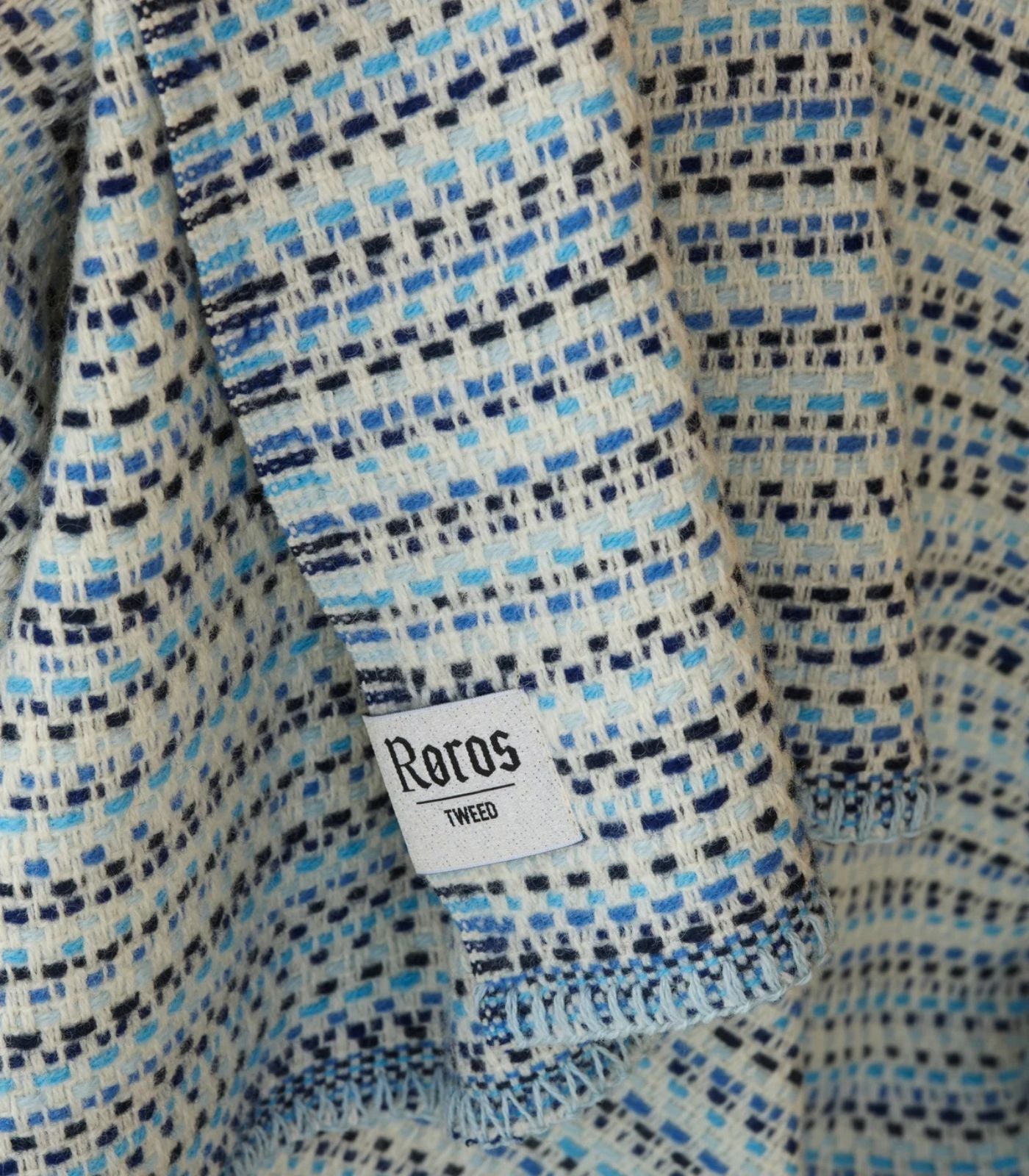 Plaid Pure Laine Juli Bleu 150 x 200 cm, Roros Tweed, drapé sur un canapé